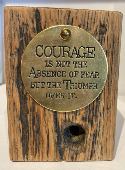Courage is not the Absence of Fear but the Triumph over it.  Inspirational quote block on Railroad wood.